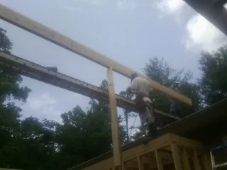 Carpenter setting a ridge beam over a new addition frame — Ice Dam Removal by Roofing Brothers in San Rafael