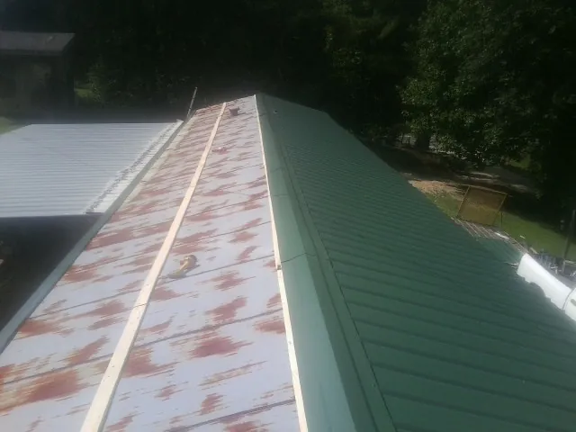 Old rusted panels beside newly installed green metal roofing — Wind Damage Roof Repair by Roofing Brothers in San Rafael