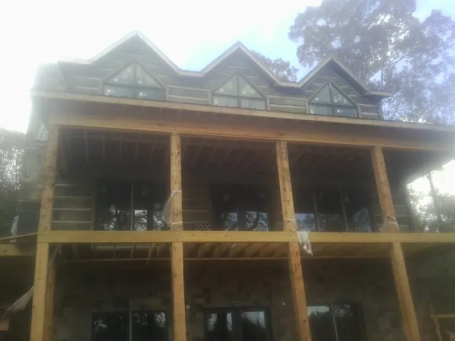 Dormers and porch framing on a large log home under construction — Roof Coating work by our crew in San Rafael