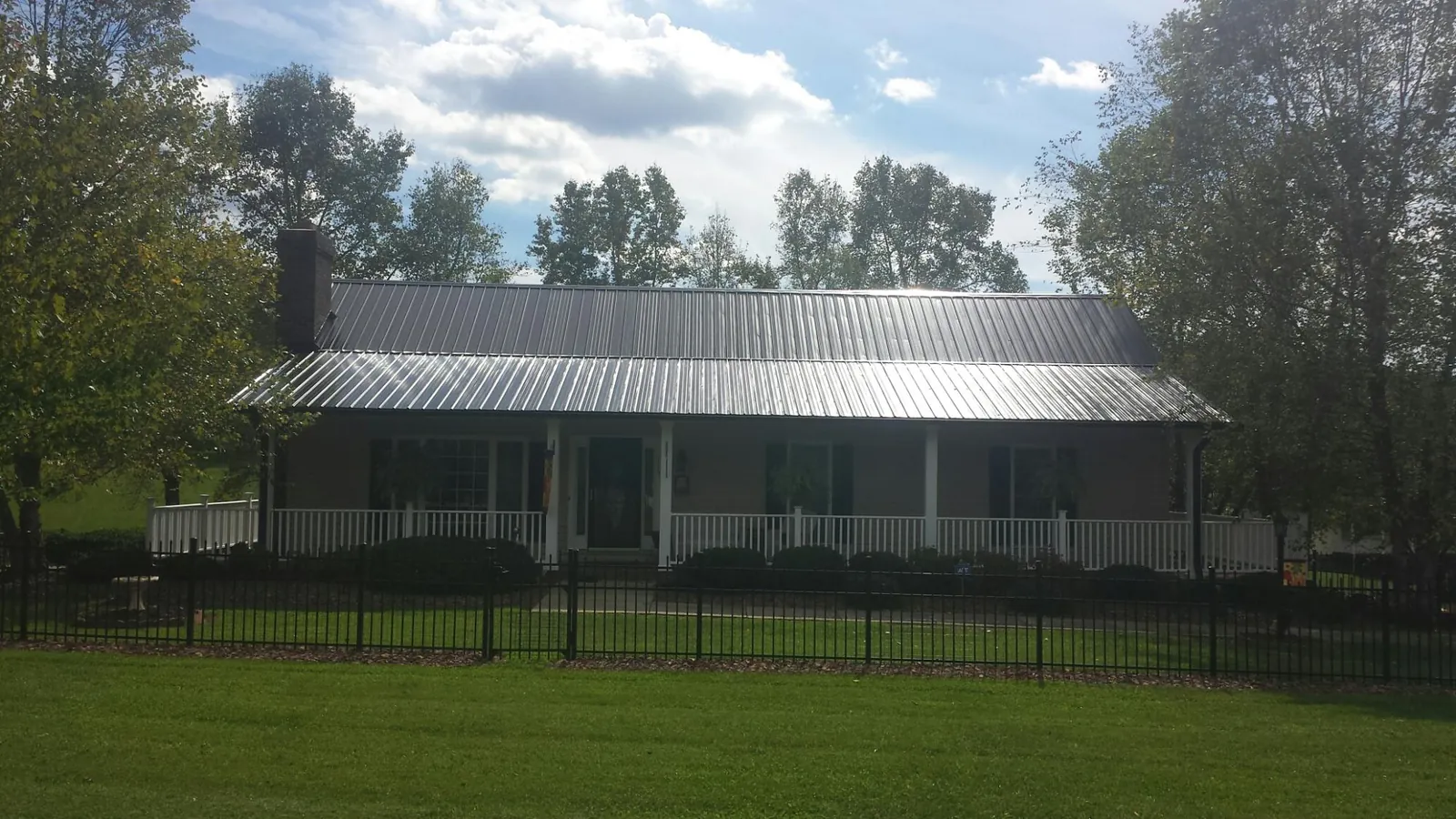 Gray metal roof on a brick ranch with a full width front porch — Gutter Guard Installation work by our crew in San Rafael